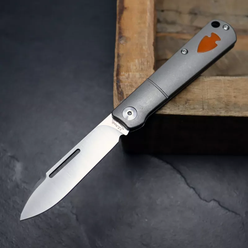 JE made Barlow 2022 Smooth Titan M390 steel slipjoint pocket knife with shield made of paper micarta in orange